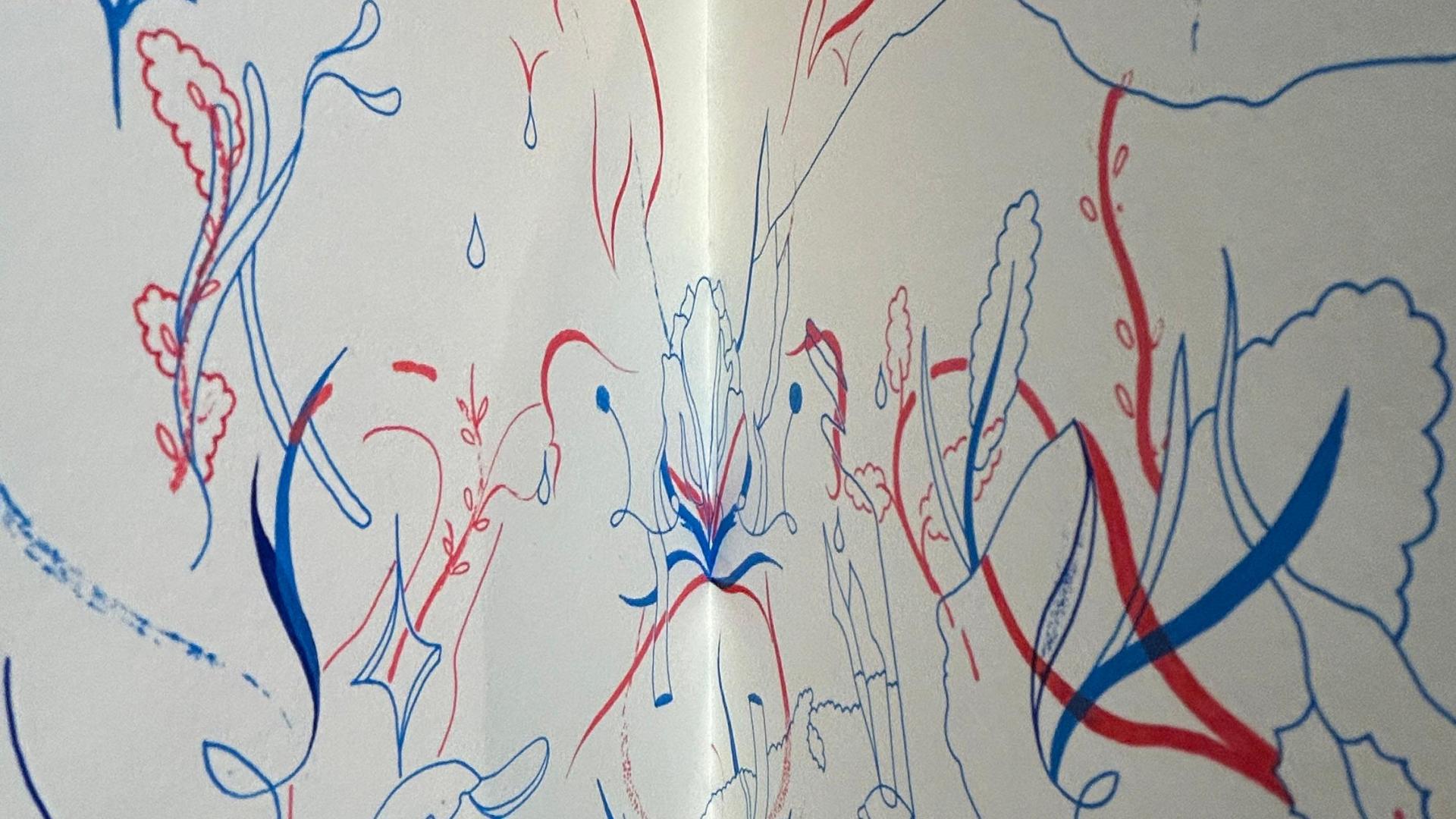 Dibujo realizado con líneas rojas y azules sobre una hoja doblada en ángulo, apoyada en un muro de ladrillo. Las líneas forman figuras orgánicas y florales entrelazadas, con trazos curvos y delicados que evocan movimiento y crecimiento natural.