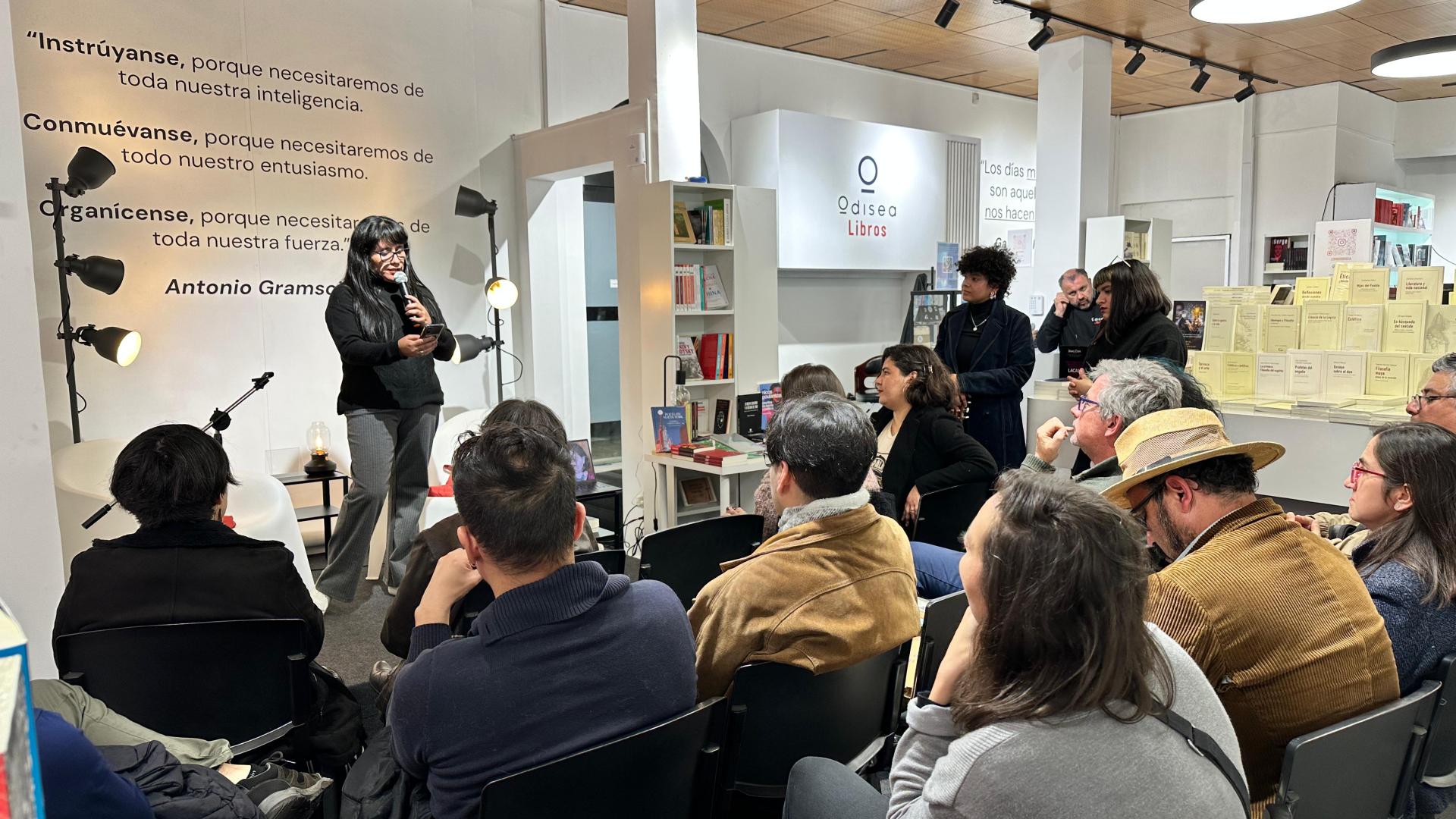 La imagen presenta a un grupo de personad disfrutando de la presentación de un conjunto de poesía. 